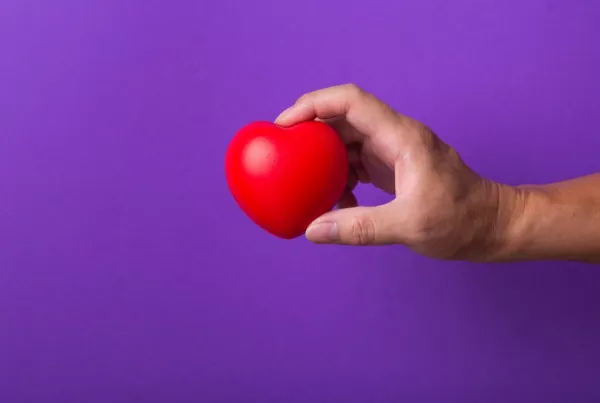 hand-with-red-heart-on-purple-background-2026-01-07-00-33-54-utc-697b75dea3e37